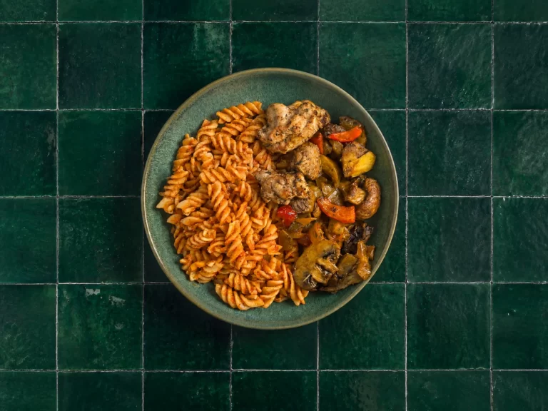 Fusilli in rijke tomatensaus met kip en gegrilde groentemix.